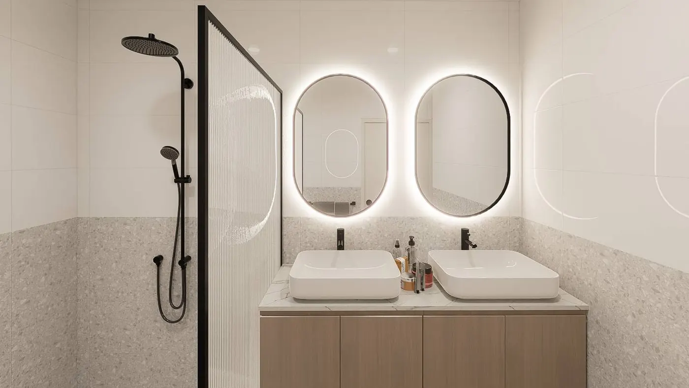 Bathroom with twin vessel basins, two backlit oval mirrors, a fluted glass shower screen and terrazzo wall tiling.